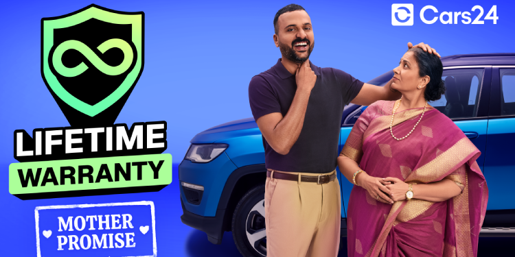 Cars24 advertisement showing a smiling man standing beside his mother in a saree near a blue car, highlighting a “Lifetime Warranty” badge and the “Mother Promise” concept to build trust through emotional and cultural connection.
