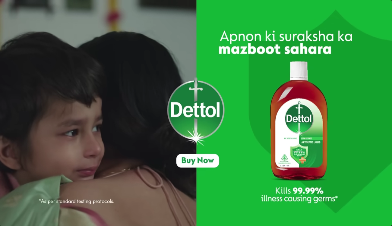 A touching scene from Dettol’s Mother’s Day advertisement showing a child emotionally hugging their mother beside a Dettol antiseptic liquid product display, highlighting family care, protection, and emotional storytelling.