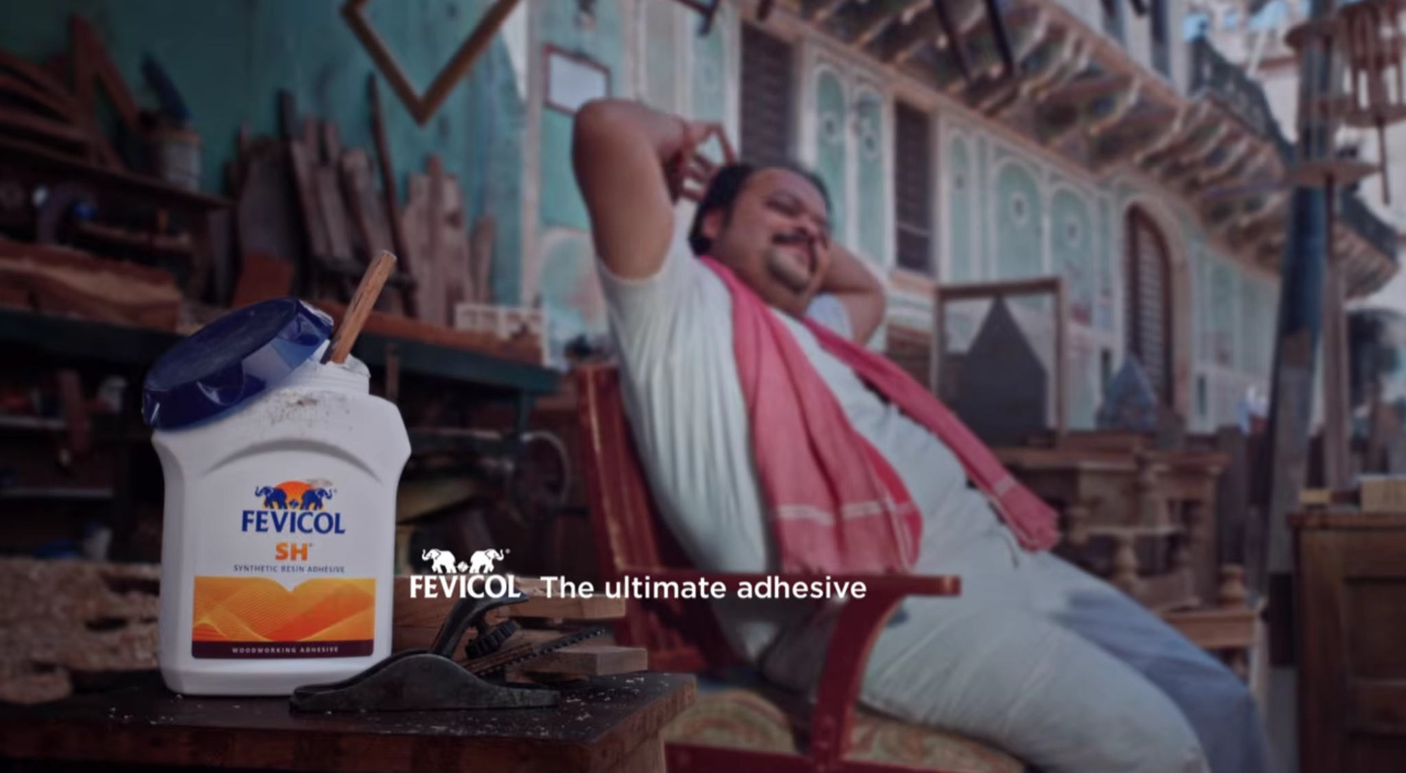 A classic Fevicol advertisement scene featuring a carpenter relaxing on a sturdy wooden chair beside a Fevicol adhesive container, showcasing why Piyush Pandey’s Fevicol storytelling still feels like a marketing miracle.