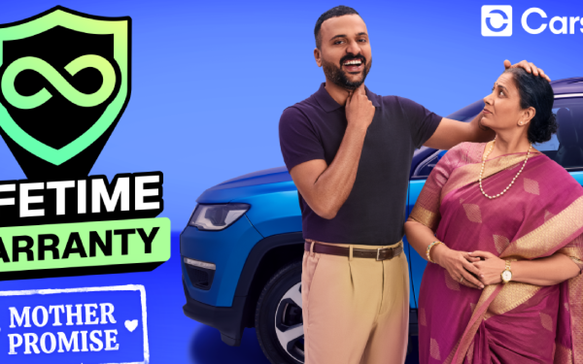 Cars24 advertisement showing a smiling man standing beside his mother in a saree near a blue car, highlighting a “Lifetime Warranty” badge and the “Mother Promise” concept to build trust through emotional and cultural connection.